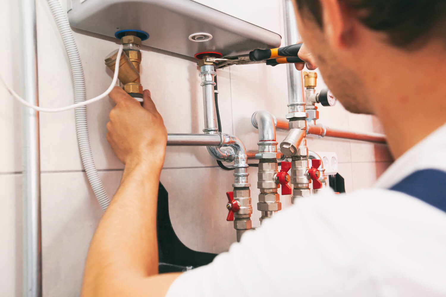 plumber-screwing-nut-pipe-heating-system-boiler-room